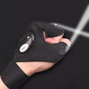 A hand wearing black tactical gloves with an on/off switch, illuminating a bright beam of light.