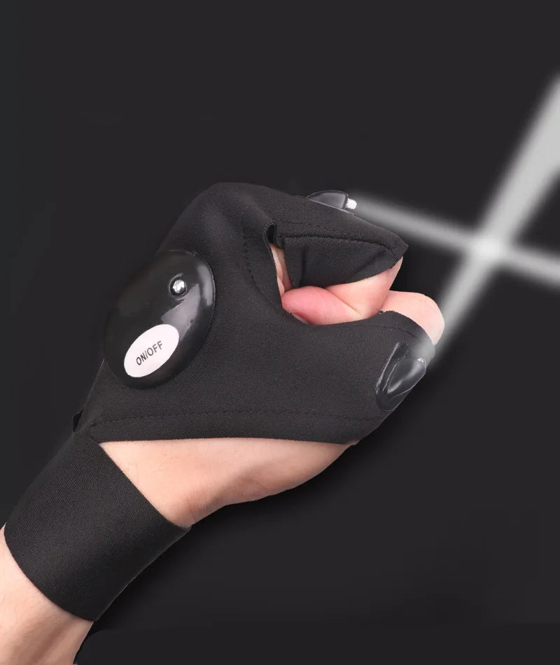 A hand wearing black tactical gloves with an on/off switch, illuminating a bright beam of light.