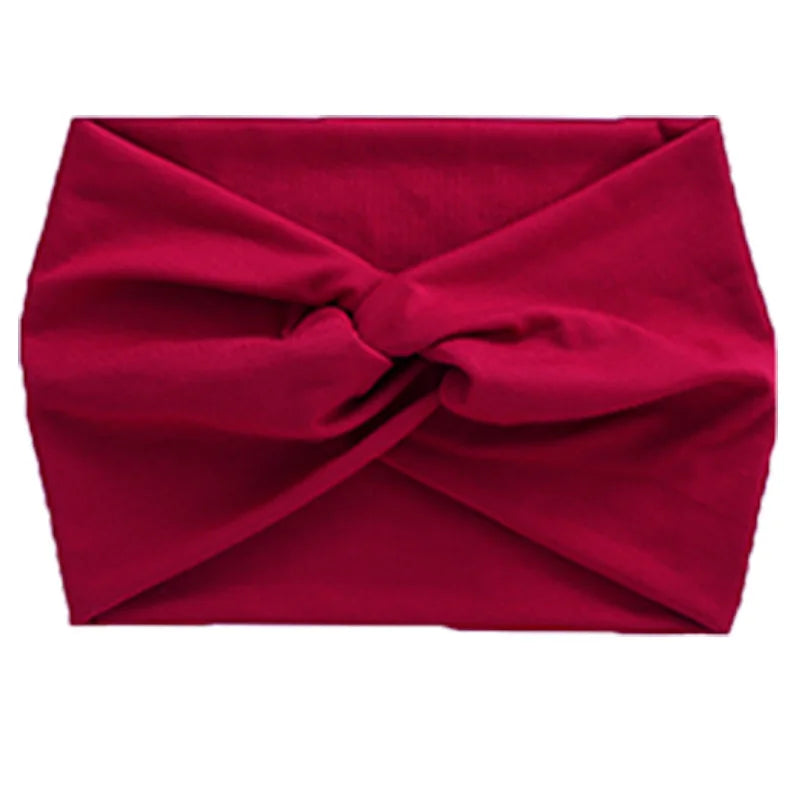 A deep red women's elastic sports headband tied in a knot.