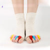 A pair of colorful five-finger yoga socks worn on a person's feet.