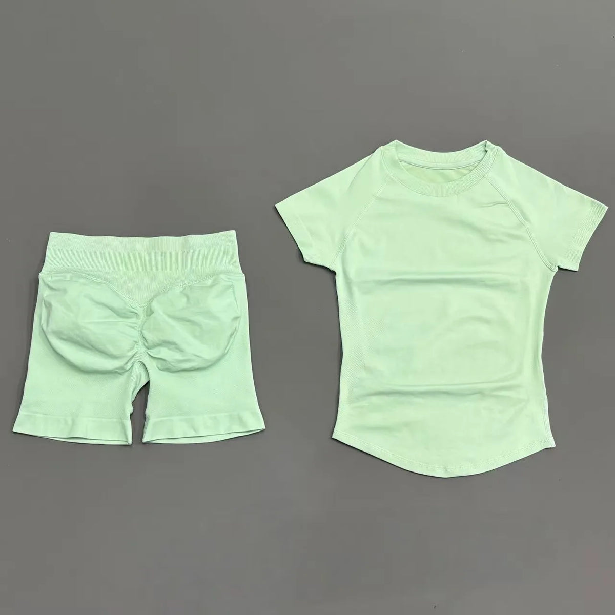 A light mint green seamless yoga set for women featuring a short sleeve top and workout leggings.
