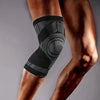 Black breathable compression knee brace worn on a person's lower leg.