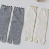 Pair of grey and white knit crew socks with ruffle cuffs
