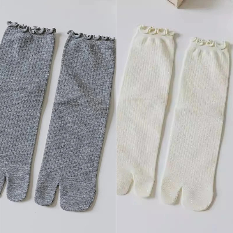Pair of grey and white knit crew socks with ruffle cuffs