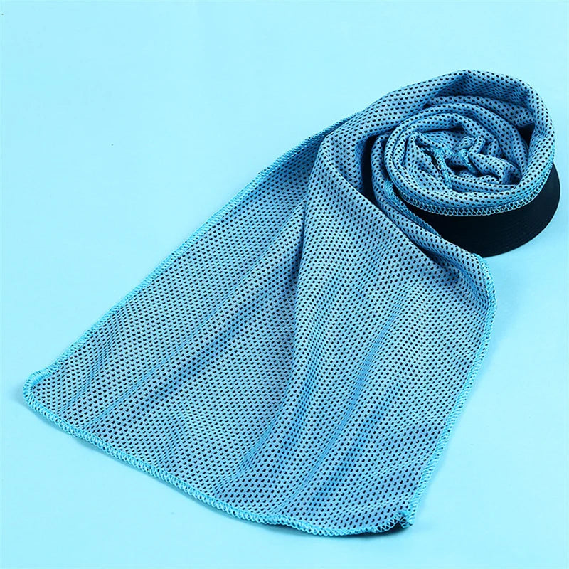 A light blue microfiber cooling towel is rolled up, showing its mesh texture against a white background.