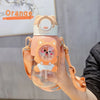 An orange leak-proof water bottle shaped like a cartoon cat, held in a hand.