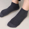 A pair of dark gray knitted bamboo fibre anti-odor socks shown on a person's foot.