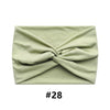 A light sage green fabric headband tied in a knot, shown flat.