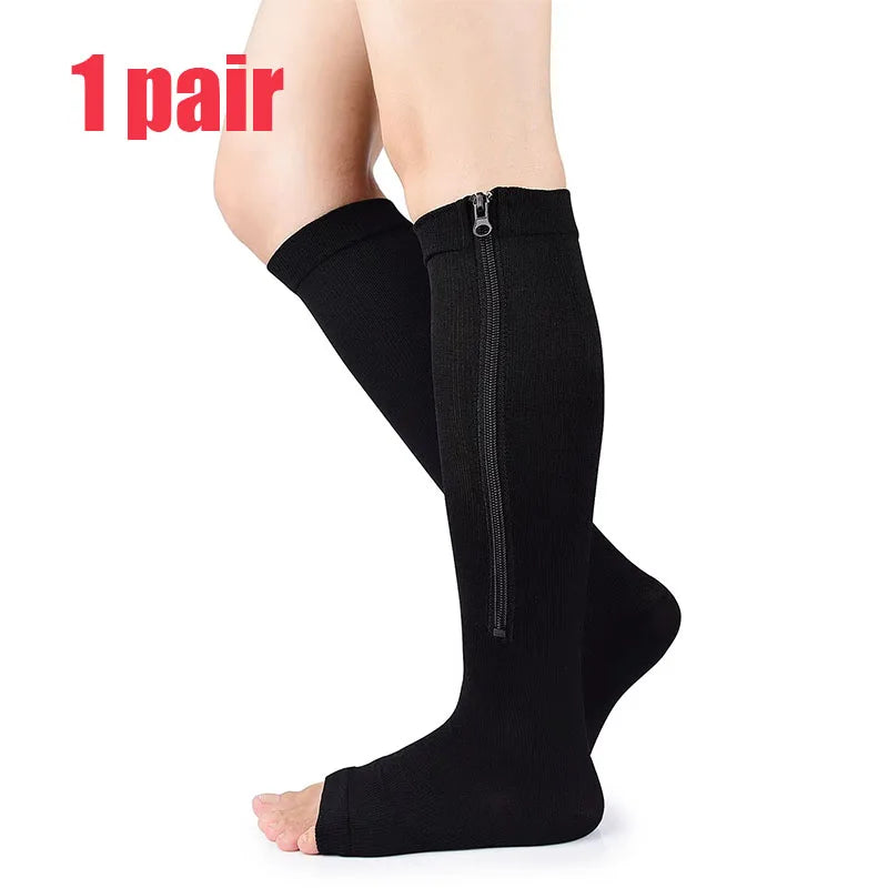 A pair of black compression stockings with a zipper, shown on a leg.