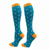 A pair of teal compression elastic socks with orange trim and white polka dots.