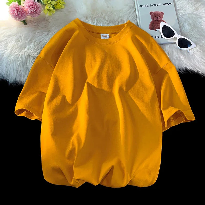 Leuchtend gelbes, überdimensioniertes weißes Baumwoll-T-Shirt neben einem kleinen Plüschtier.