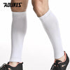 White compression leg sleeves worn on a person's lower leg.
