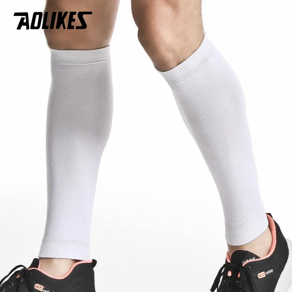 White compression leg sleeves worn on a person's lower leg.