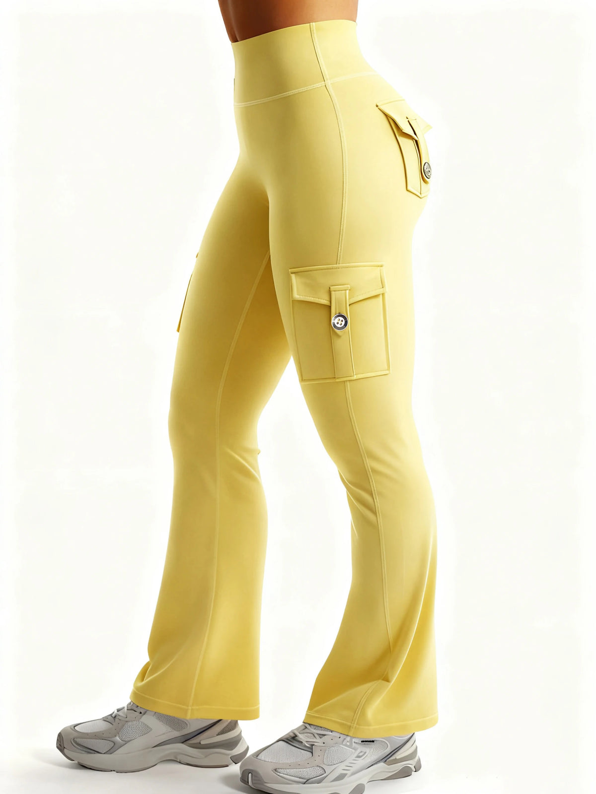 A model wears high-waisted yellow flared fitness pants with multiple pockets and gray athletic shoes.