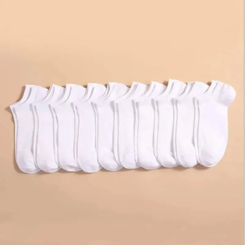A row of white breathable unisex boat socks laid out on a light beige background.