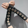 Gros plan d'un bandeau en œillet punk grunge noir porté à la main.
