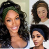 Une femme modélise un foulard en coton bohème vert olive foncé noué en nœud dans ses longs cheveux bouclés et foncés.