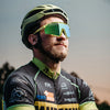 A male cyclist wearing photochromic cycling sunglasses outdoors.