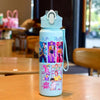A light blue cartoon character water bottle with a carrying strap sitting on a wooden table.