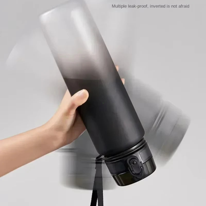 A hand is holding a black sports water bottle, demonstrating its leak-proof feature.