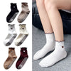A collection of embroidered yoga socks in black, beige, and maroon for Pilates and workout.