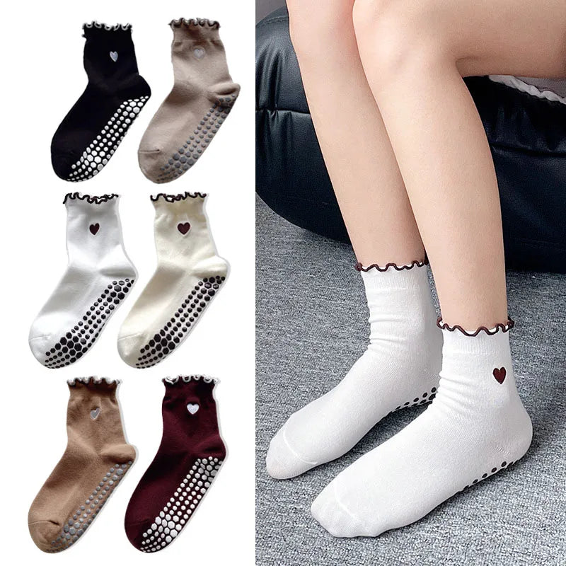 A collection of embroidered yoga socks in black, beige, and maroon for Pilates and workout.