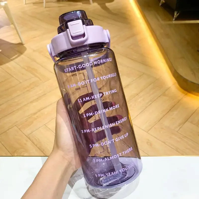 Une bouteille d'eau sportive violette avec des marqueurs de temps, tenue contre un fond en bois.