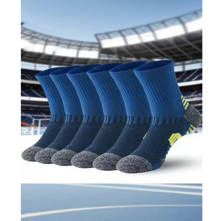 A pack of blue performance running socks with gray toe grips displayed against a blurred sports stadium background.