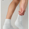 A close-up of a person putting on white breathable sports performance socks