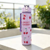 A purple reusable water bottle with a strawberry design sitting on a white surface.