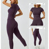 Model trägt ein lila Zweiteil-Yoga-Set mit hohen Leggings und einem kurzen Top.