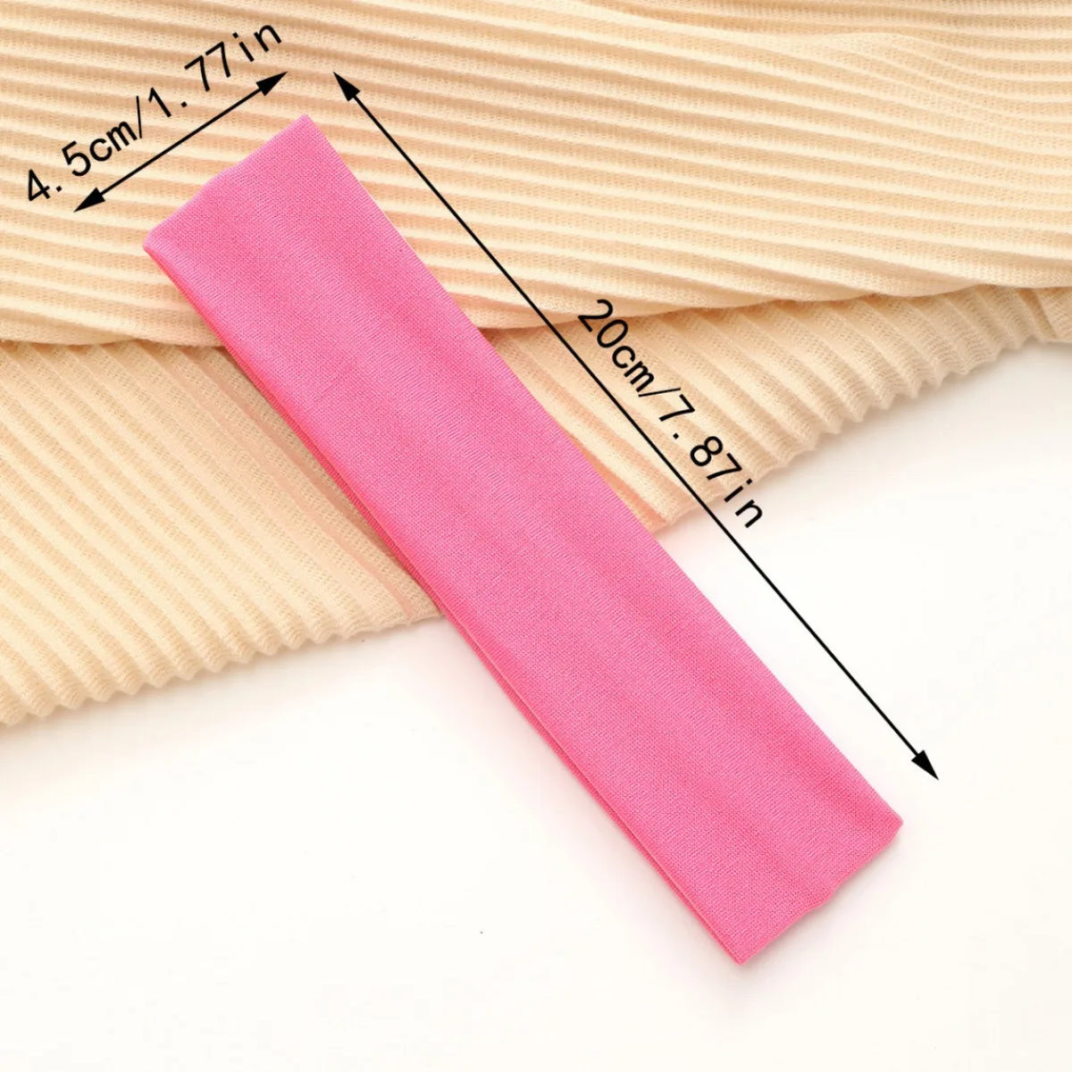 A pink stretchable cotton sweat absorbing headband is shown next to a beige ribbed fabric, with dimensions marked.