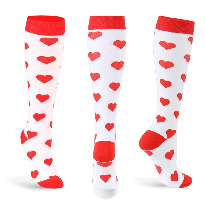 A set of white compression elastic socks with red heart patterns and red cuffs.