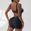 A woman models a black tie-dye sport jumpsuit from the back view.
