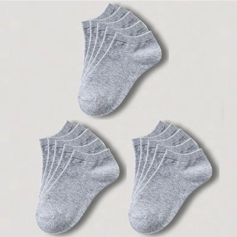 Una pila de calcetines de algodón unisex grises y transpirables, colocados sobre un fondo claro.