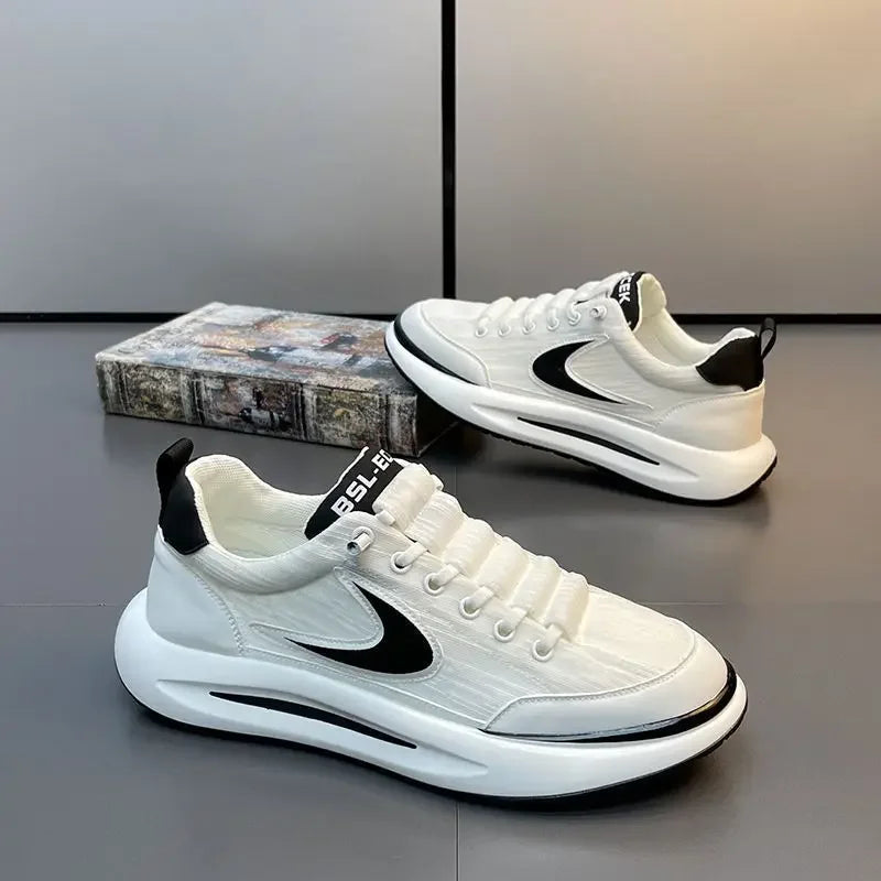 A pair of white and black men's breathable mesh running shoes resting on a gray surface.