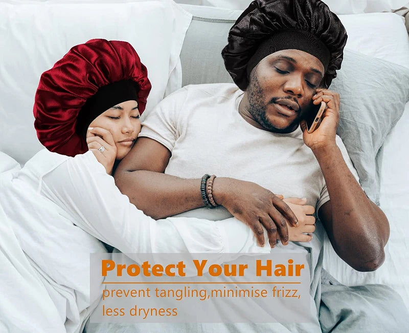 A man wearing a black bandana is talking on a phone while lying in bed with white sheets.