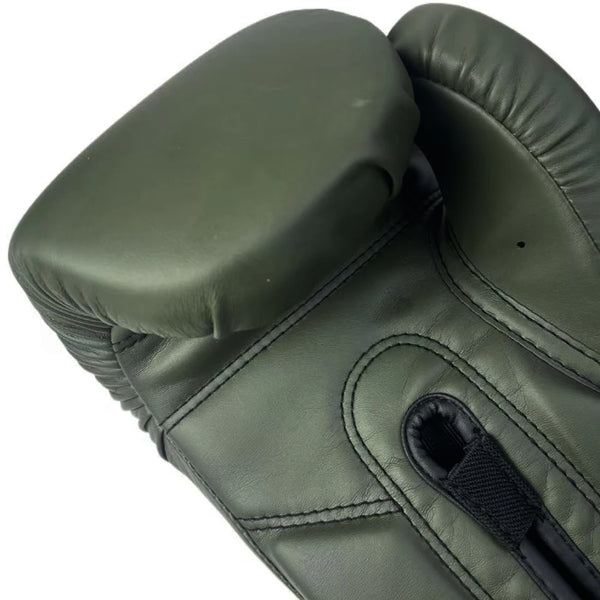 A close-up view of a dark olive green PU leather boxing glove with a padded thumb section.