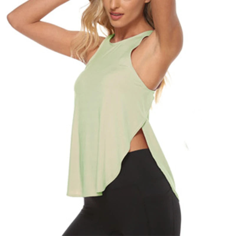 A woman wearing a light sage green quick-dry yoga and gym tank top and black leggings.
