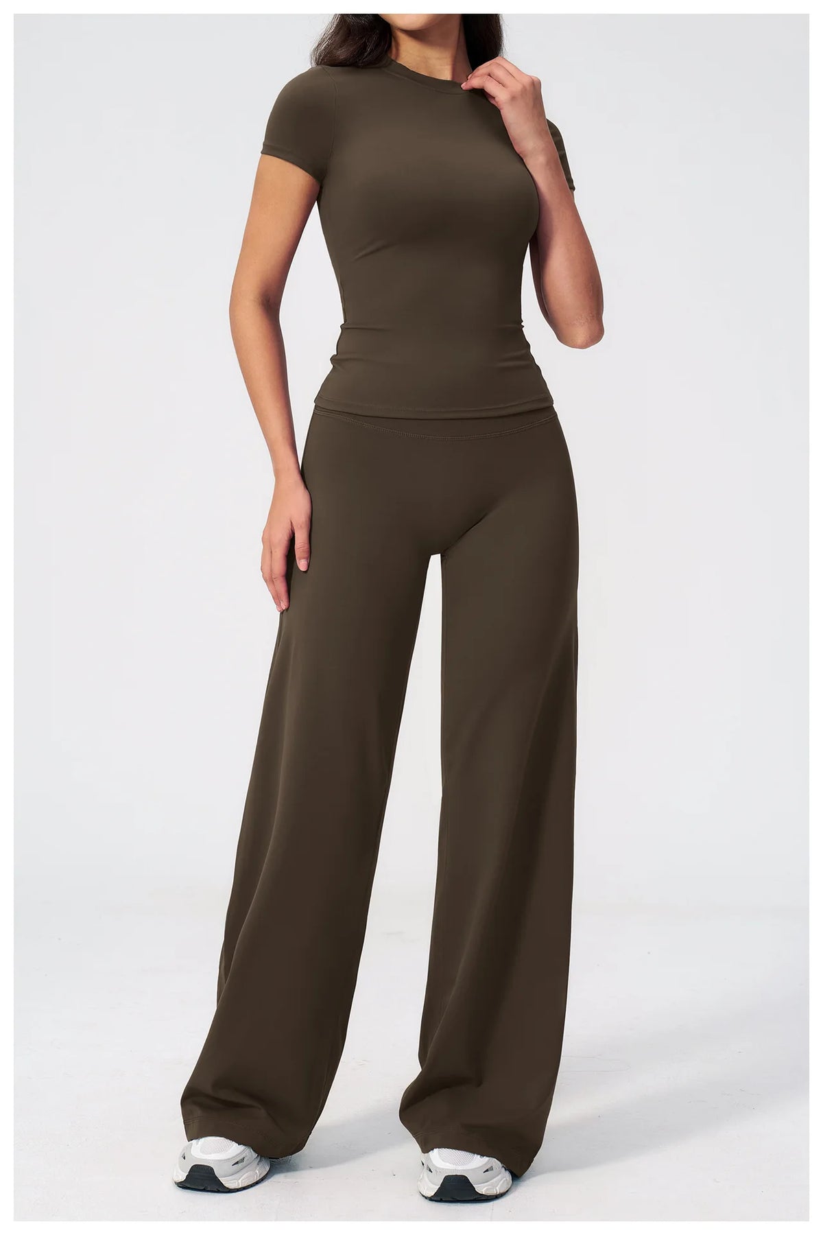 A woman wearing a dark olive green high-waist yoga and gym leggings set.