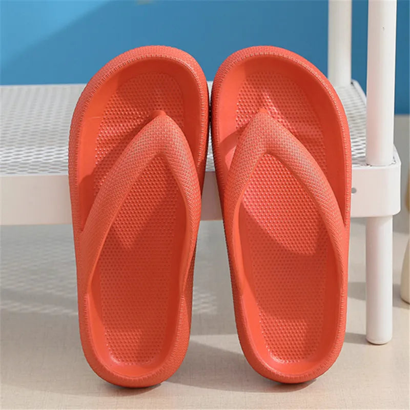 Pair of bright orange comfort platform flip flops resting on a white surface.
