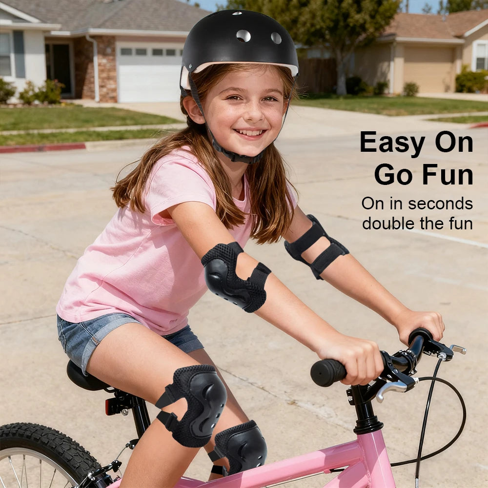 A smiling girl wearing a black helmet and protective gear riding a pink bicycle.