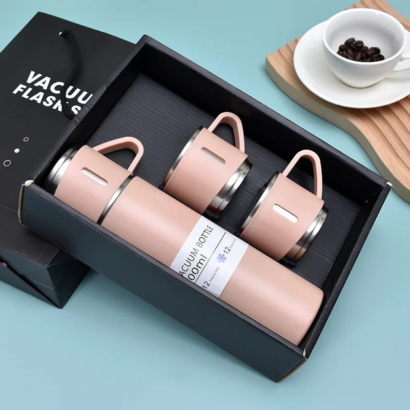 A pink vacuum flask in a black box with a lid, showing the bottle and a separate flask.