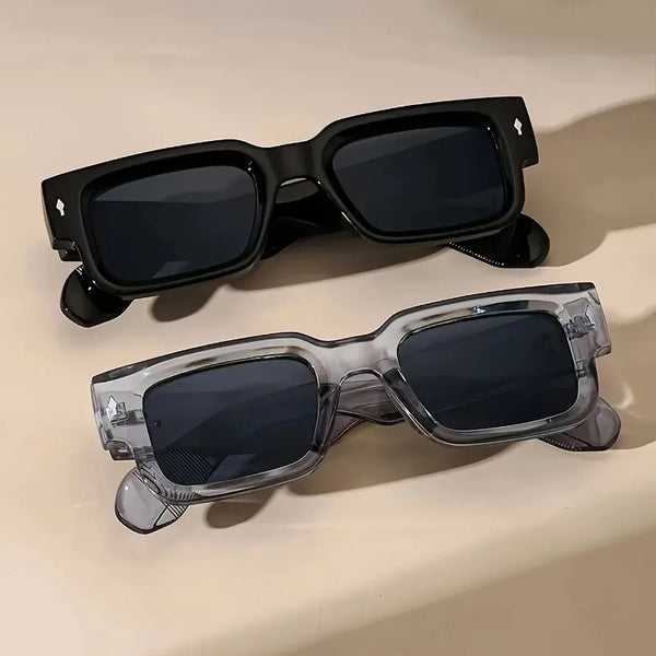 A pair of black retro square sunglasses with UV400 protection resting on a light surface.