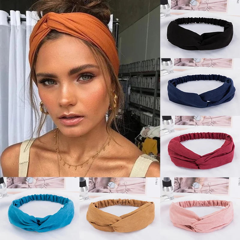 A collection of fabric headbands in various colors including orange, navy blue, maroon, teal, tan, and pink.