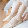 A pair of beige silicone anti-slip summer socks worn on a person's foot, resting on white fabric.