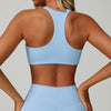 A woman wearing a light blue padded sport yoga bra and matching bottoms, shown from the back.