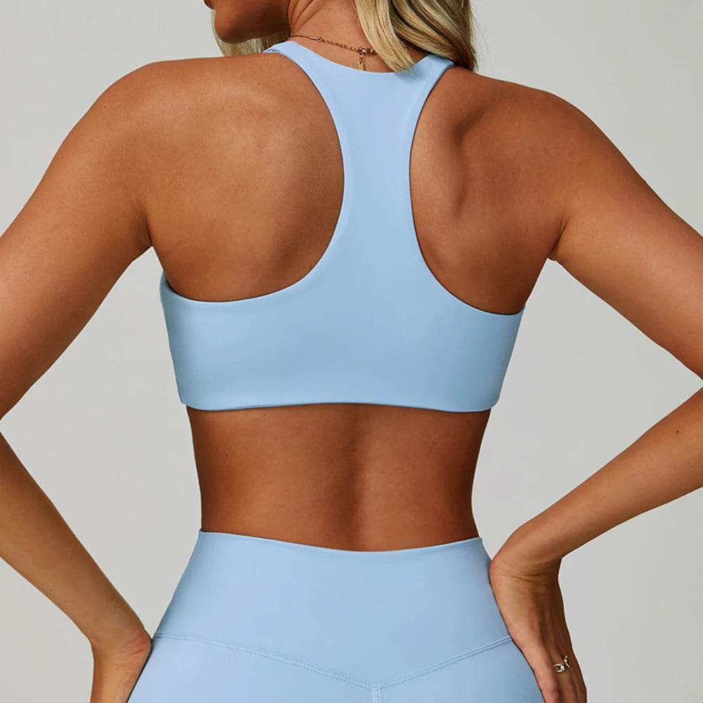 A woman wearing a light blue padded sport yoga bra and matching bottoms, shown from the back.