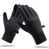 Un par de guantes de invierno impermeables y táctiles negros, mostrados contra un fondo blanco.