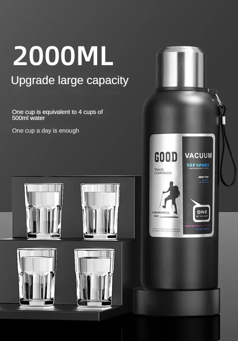 Botella térmica negra con tapa plateada y compartimento para varias tazas de vidrio.